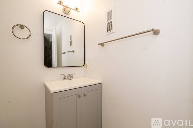 A bathroom with a white sink and a mirror above it.