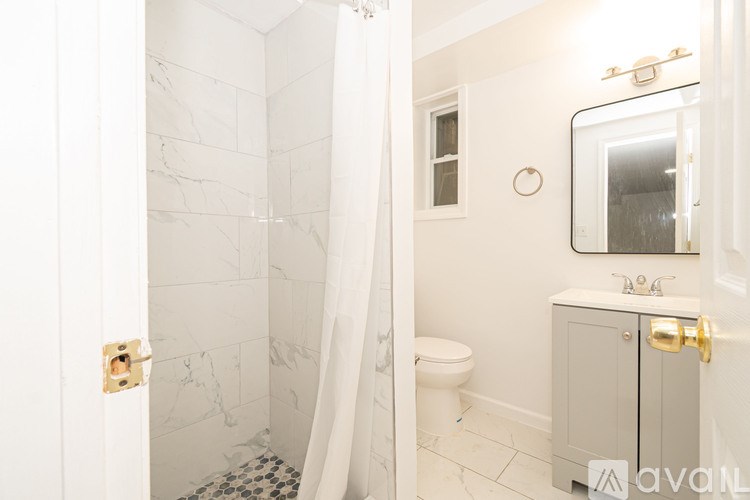 A bathroom with a toilet, sink, and shower.