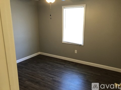 A room with a window and a hanging light fixture.