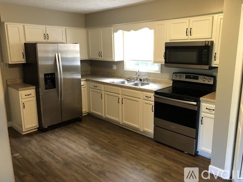 A kitchen with white cabinets and stainless steel appliances.
