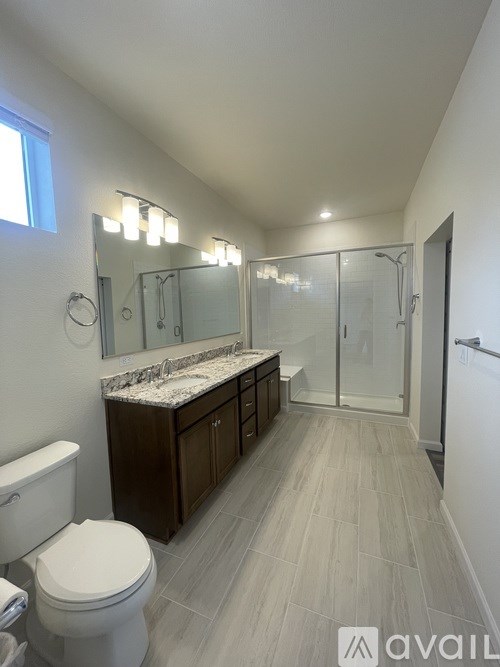 A bathroom with a toilet, sink, and walk-in shower.