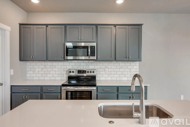 A kitchen with a white counter top and a stove top oven.