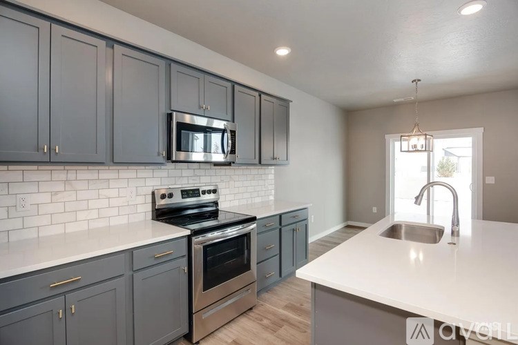 A kitchen with a stove, oven, microwave, and sink.