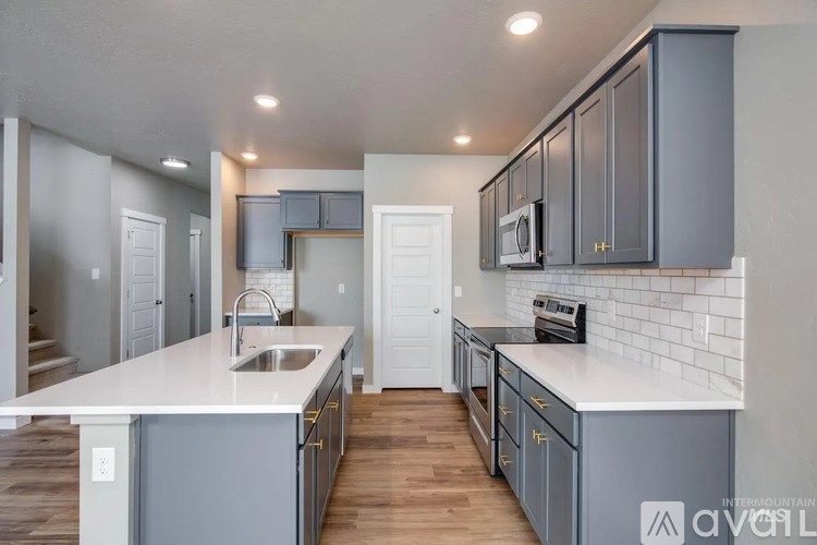 A kitchen with a white countertop and grey cabinets.