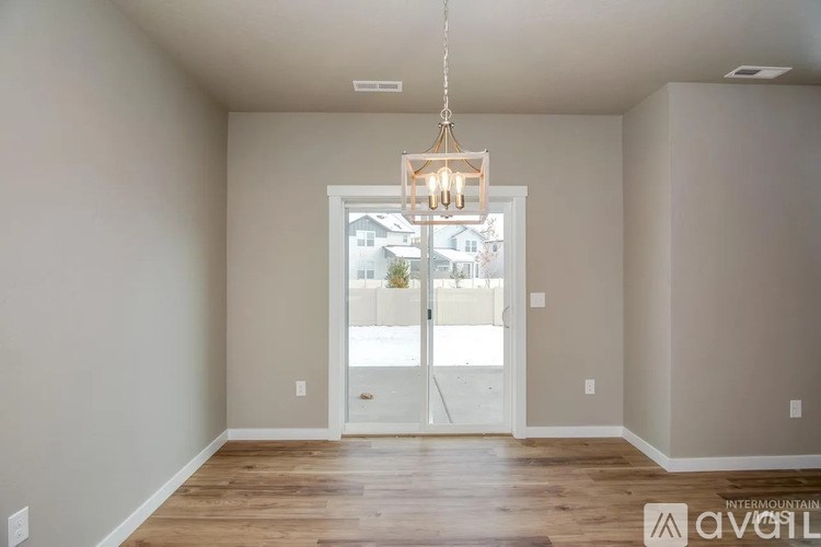 A room with a wooden floor and a chandelier hanging from the ceiling.