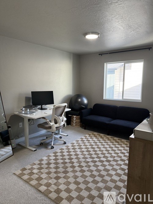 A room with a desk, chair, and couch.