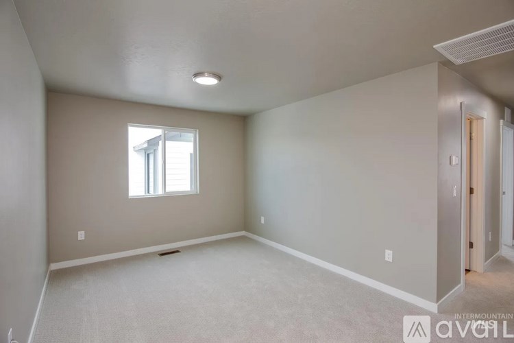 A room with a window and carpeted floor.