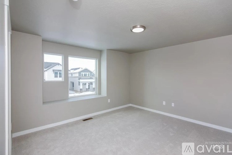 A room with a window and a mirror on the wall.