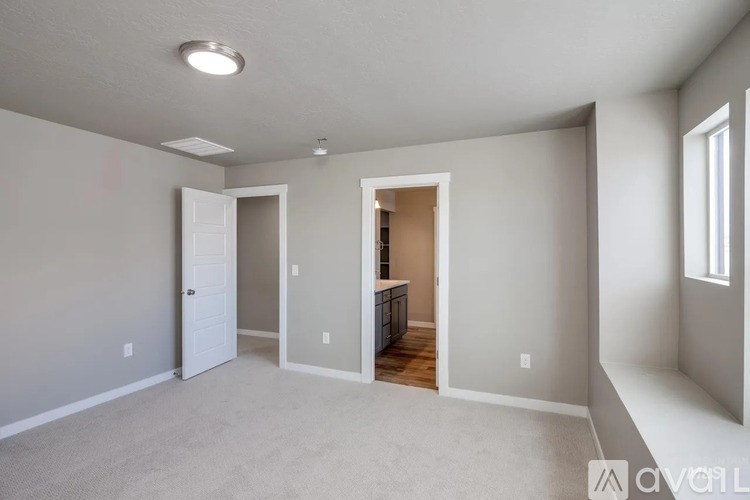 A spacious room with a doorway leading to another room.