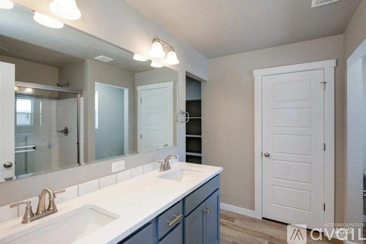 A bathroom with a white countertop and a white sink with a gold faucet.