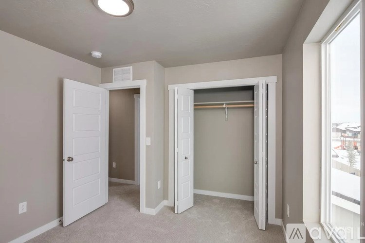 A room with a white door and a window with a view of a snowy landscape outside.
