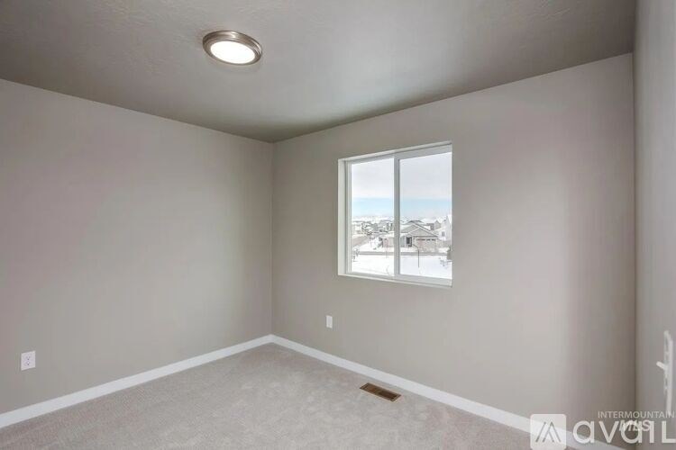A room with a window showing a view of buildings outside.