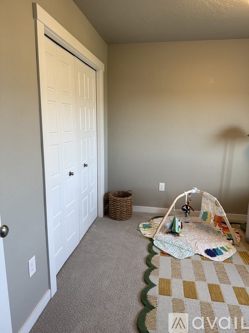 A room with a white door and a carpet with a checkered pattern.