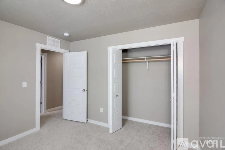 A room with a white door and a white closet with a coat hanger.