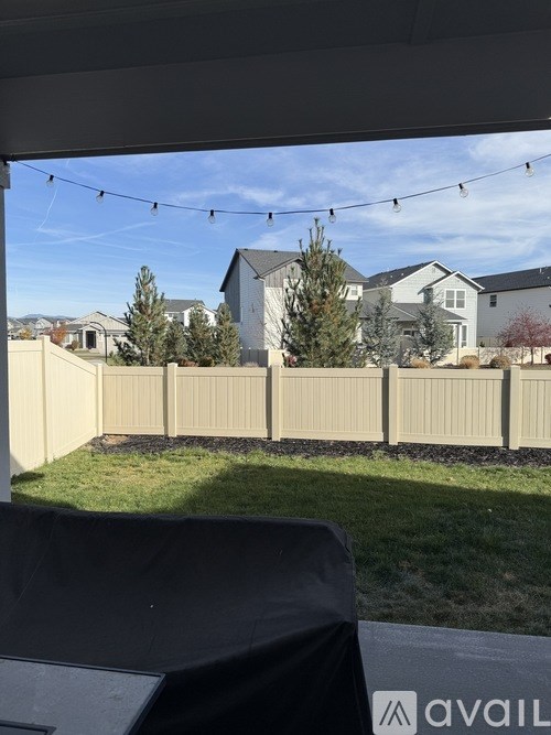 A backyard with a fence and a tree.