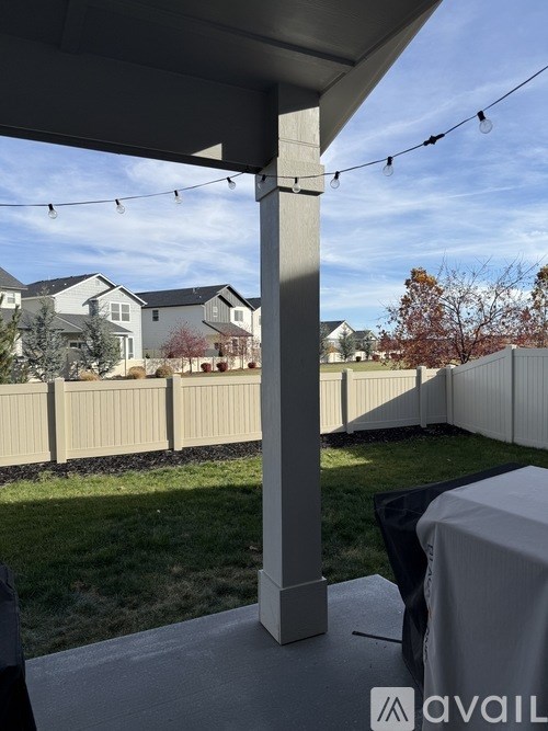 A patio with a table covered in a white cloth and a view of a residential area.