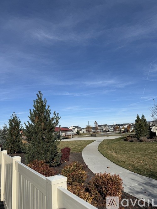 A white fence with a view of a residential area.