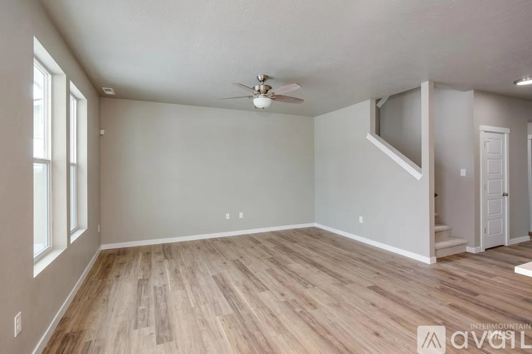 A room with wooden flooring and a ceiling fan.