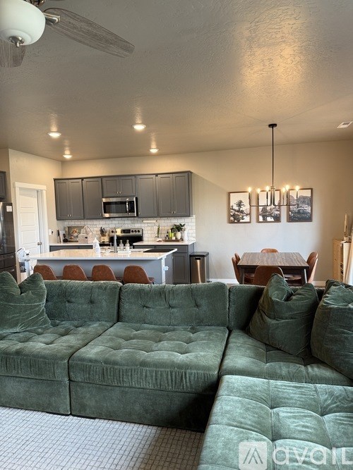 A green velvet sofa in a modern kitchen and dining area.