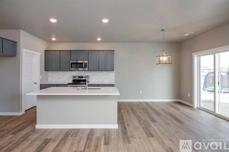 A kitchen with a white island and wooden floors.