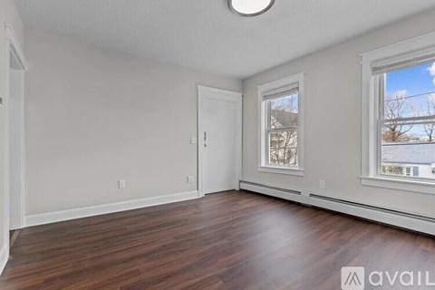 A room with wooden floors and a window showing a snowy landscape outside.