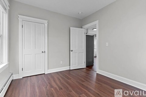 A room with wood flooring and two white doors.