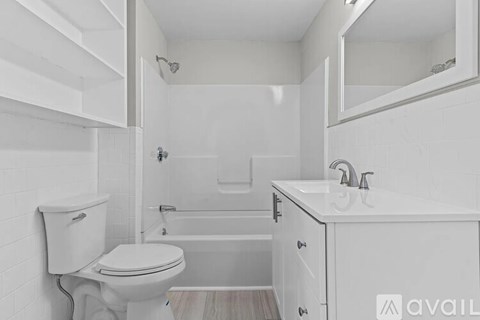 A white bathroom with a toilet, sink, and bathtub.
