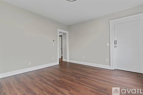 A room with wooden floors and two doors.