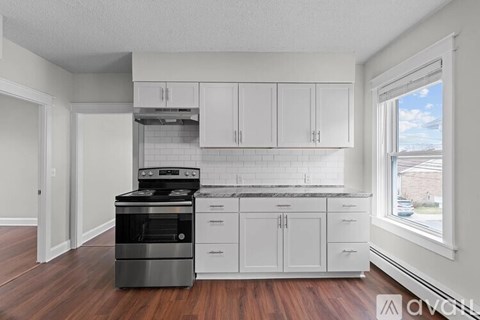 A kitchen with white cabinets and a black stove top oven.