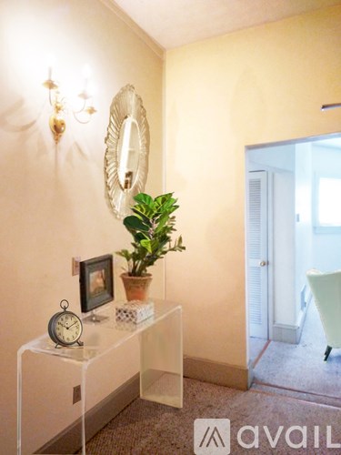 A white table with a clock, picture, and plant on it.