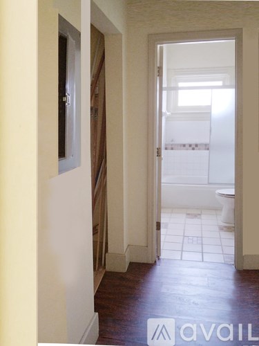 A hallway with a toilet in the distance.