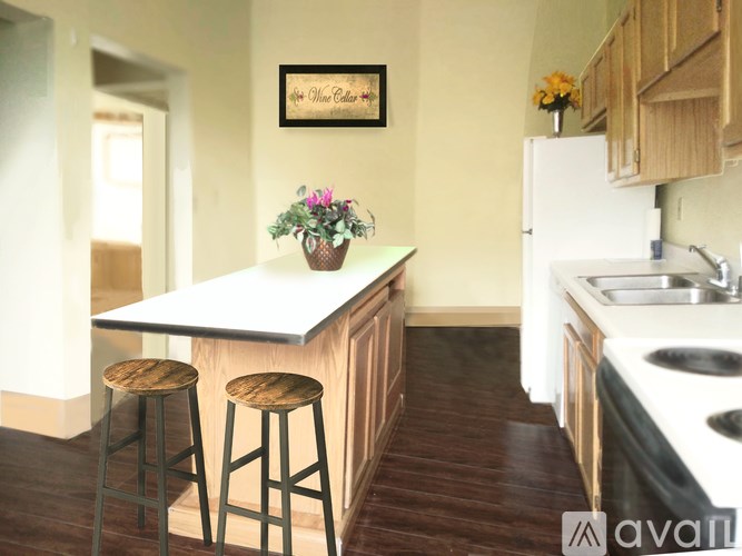 A kitchen with a white countertop and wooden stools.
