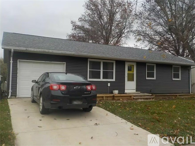 A black car is parked in front of a garage.
