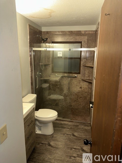 A bathroom with a toilet, sink, and shower.