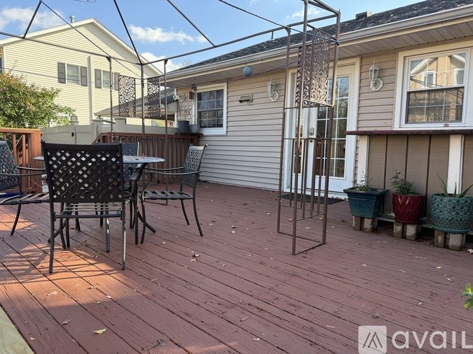 A patio with a table and chairs and a screened in area.