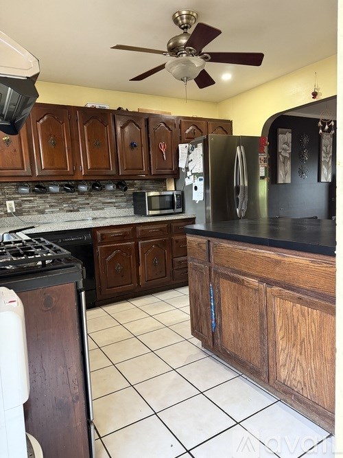 A kitchen with wooden cabinets and a black countertop.