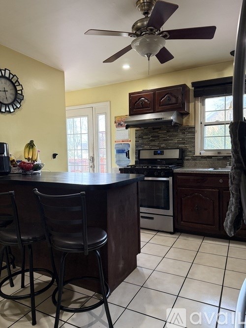A kitchen with a bar area and a clock on the wall.