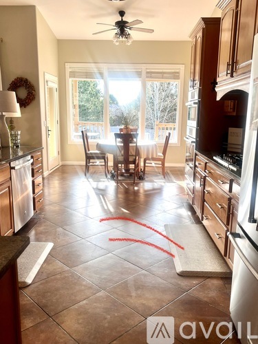A kitchen with tile flooring and a ceiling fan.