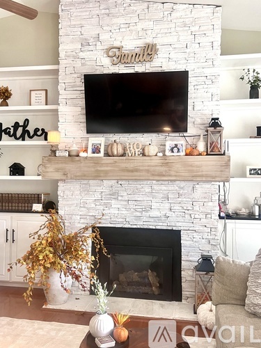 A living room with a fireplace and a tv above it.