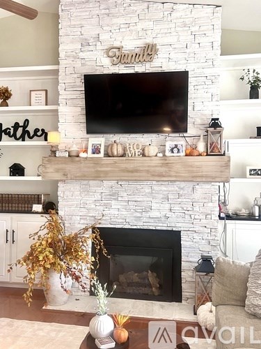 A living room with a fireplace and a tv above it.