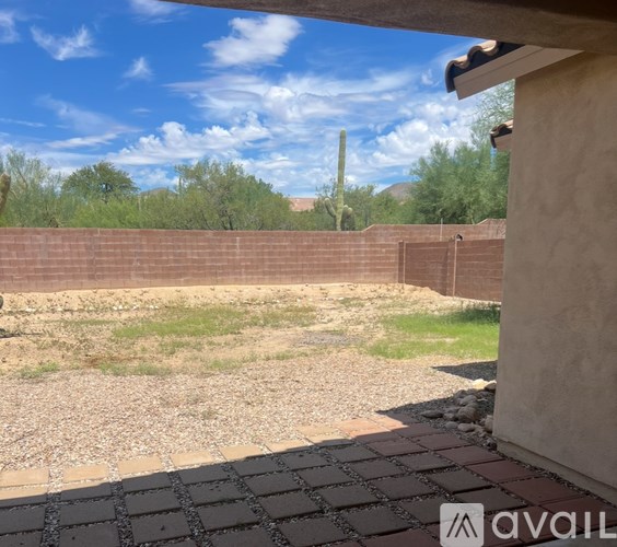 A white toilet sits in a bathroom with marble walls and a white bathtub.