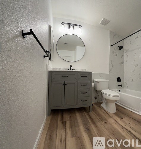 A white bathtub with a marble wall behind it.