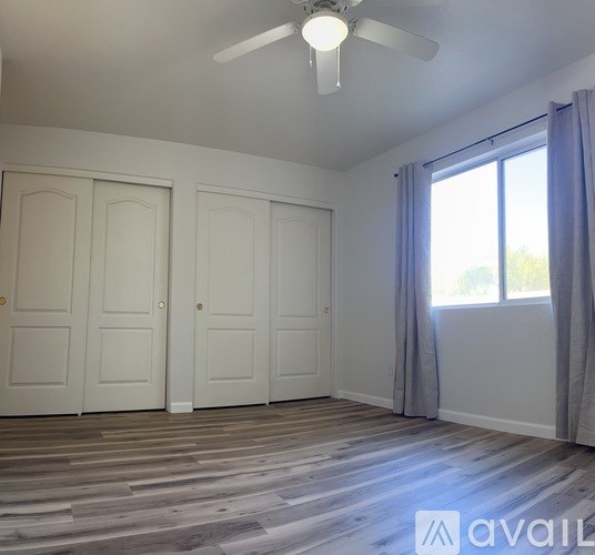A room with wooden flooring and a ceiling fan.