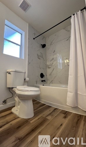 A kitchen with wooden cabinets and a black dishwasher.
