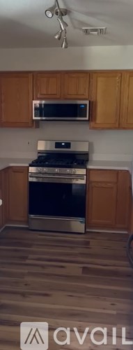 A kitchen with wooden cabinets and a stainless steel oven.