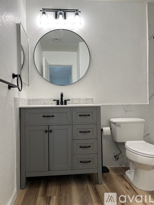 A room with a ceiling fan and wooden flooring.