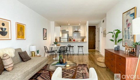 A living room with a grey couch, a coffee table, and a dining table with chairs.