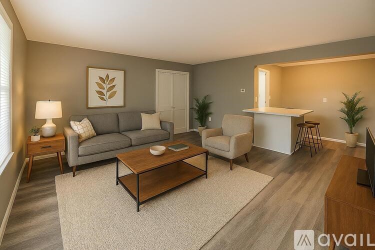 A living room with a grey couch, a wooden coffee table, and a television.