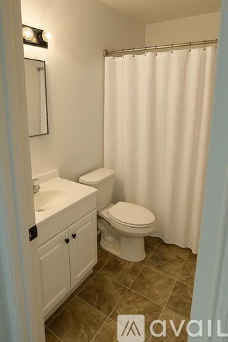 A white toilet and sink in a bathroom.