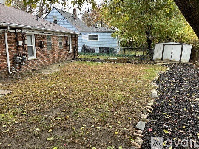 A backyard with a fence and a shed.